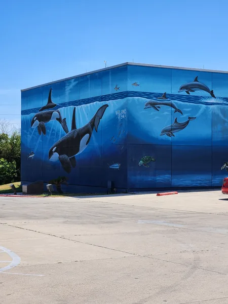 A blue marine-life mural with whales, dolphins and a sea turtle wraps around the Convention Centre exterior.