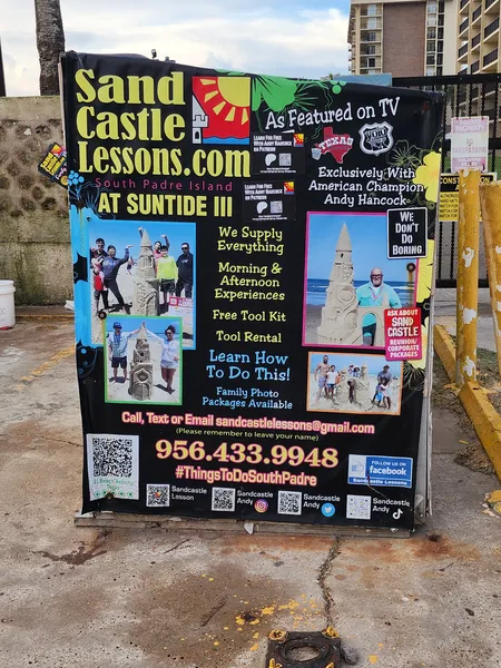 A Sand Castle Lessons sign with photos of sand sculptures and families, advertising lessons at the Suntide III.