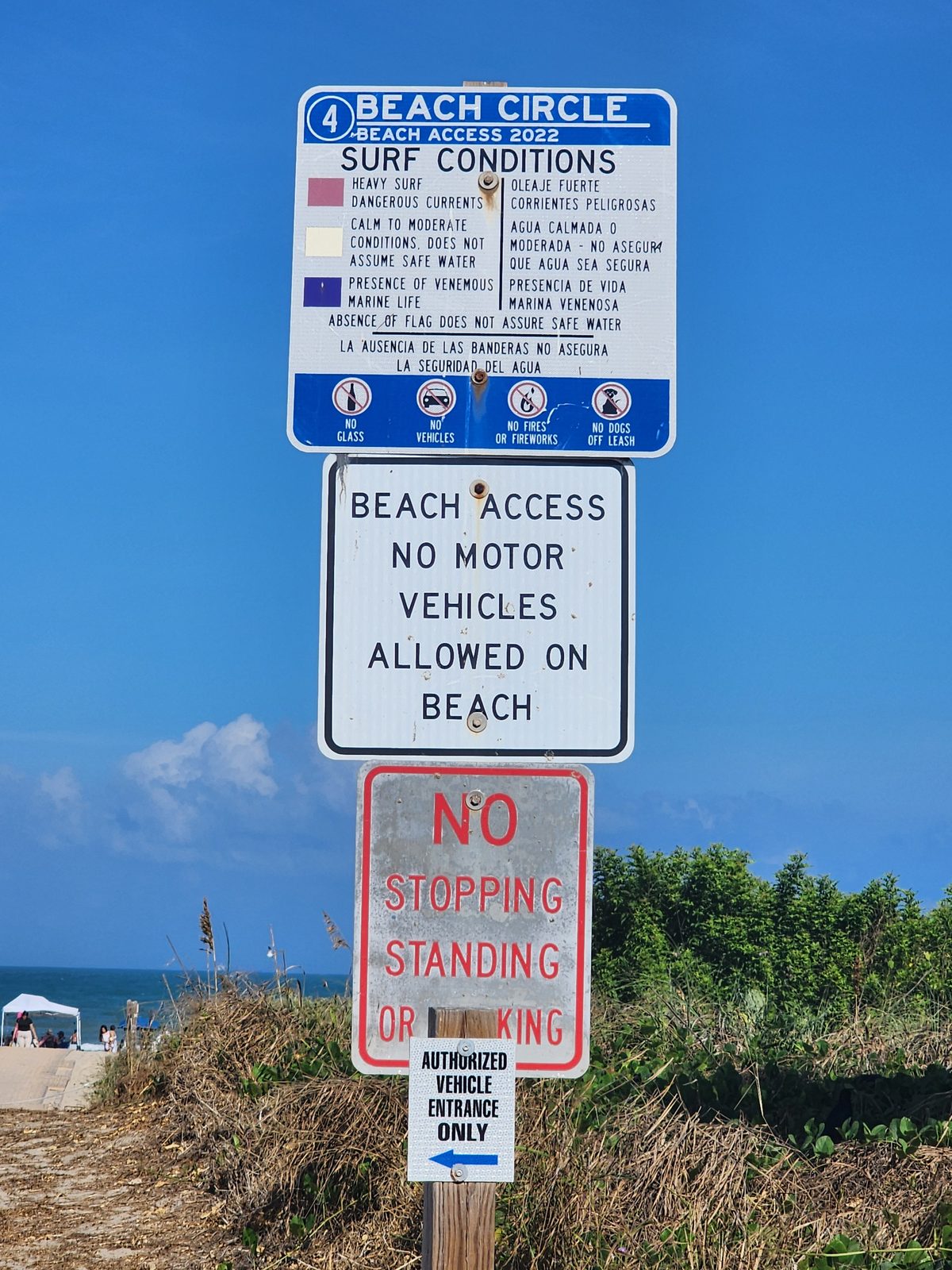 A Beach Circle sign lists surf conditions and access restrictions.