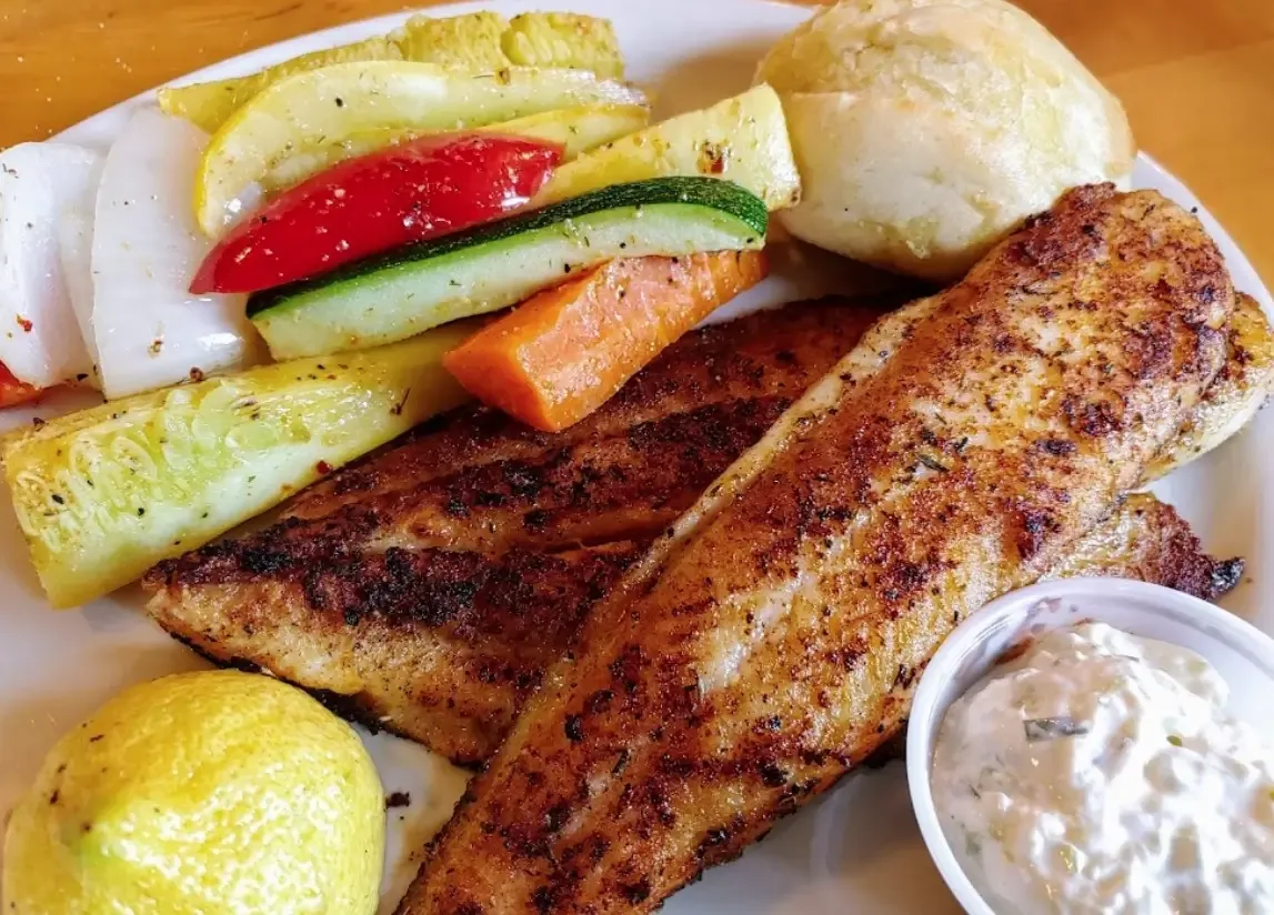 Two blackened fish fillets with grilled zucchini, squash, peppers and carrots, a roll and tartar sauce