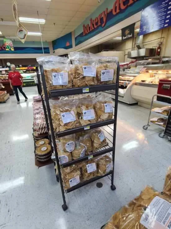 A rack of bagged tortilla chips near the bakery-deli counter