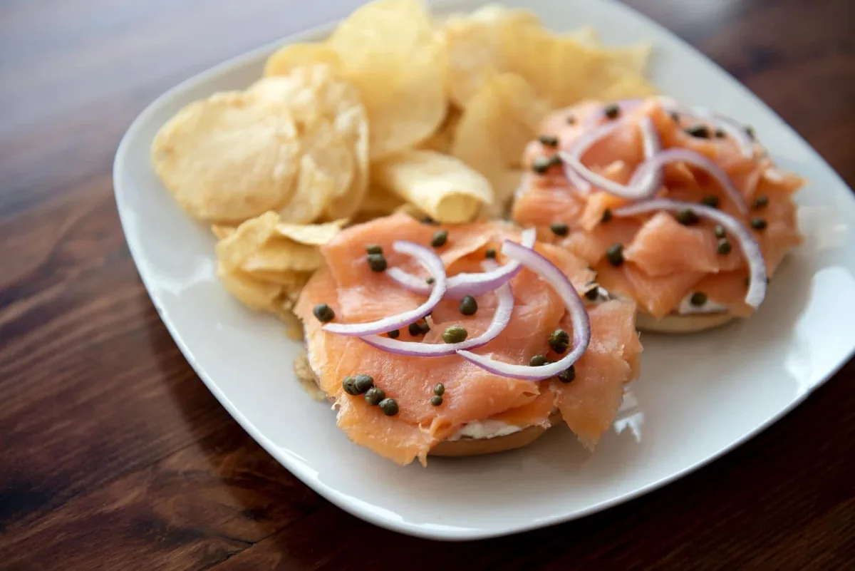Bagel halves topped with cream cheese, smoked salmon, capers and red onion, with potato chips