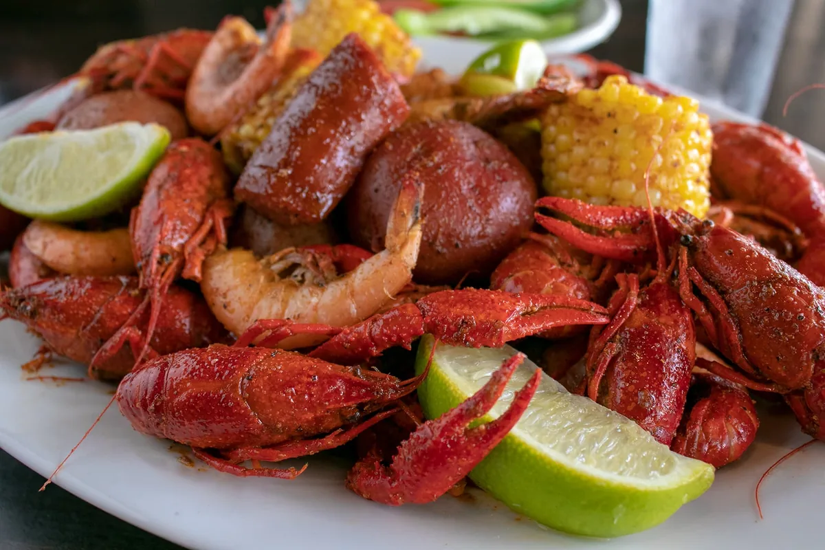 A platter of Cajun-boiled crawfish and shrimp with sausage, corn on the cob, red potatoes and lime wedges