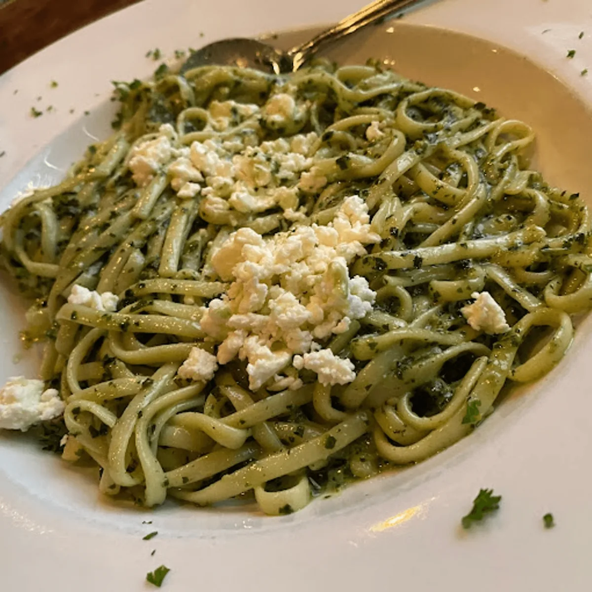 Linguine in pesto sauce topped with crumbled feta cheese