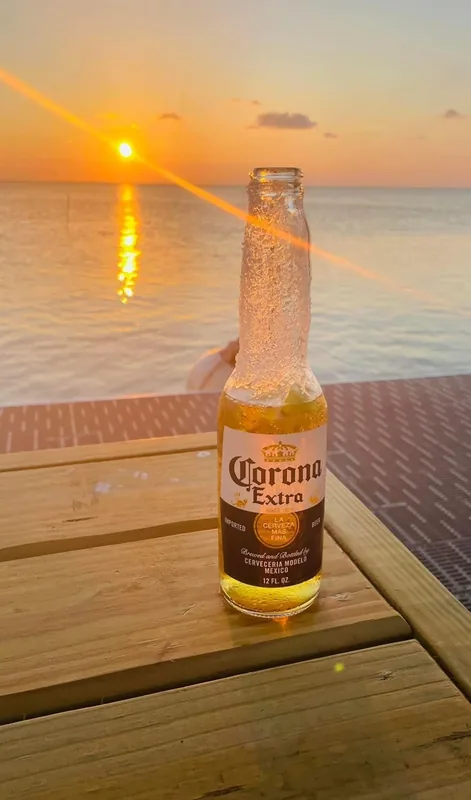 A bottle of Corona Extra on the deck at sunset at Longboard Bar & Grill