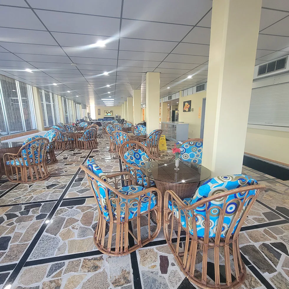 Lobby seating with wicker chairs and blue patterned cushions by the windows
