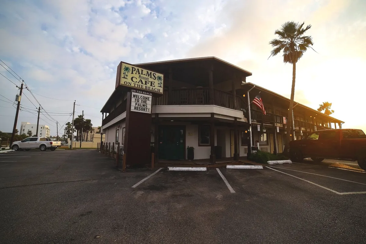 The Palms Resort building with its Palms Cafe on the Beach sign at sunrise