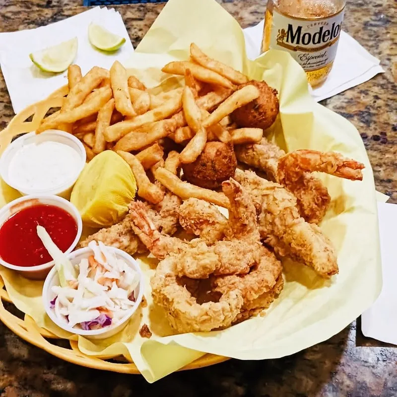 A fried seafood combo basket with fries and coleslaw at Palms Resort & Cafe on the Beach