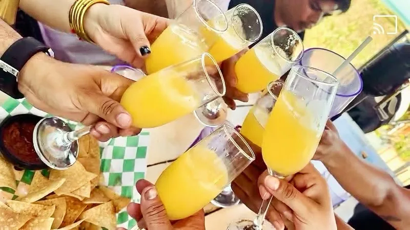 A toast with glasses of orange-juice mimosas at Palms Resort & Cafe on the Beach