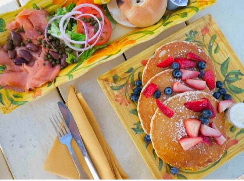 Palms Malted Pancakes with fresh berries at Palms Resort & Cafe on the Beach, with a lox and bagel plate beside them
