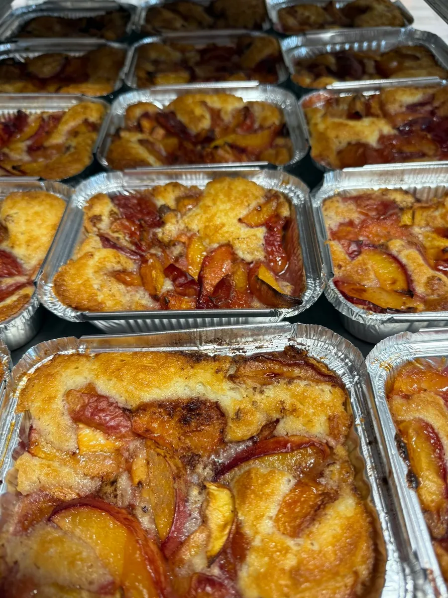 Rows of peach cobblers in foil pans