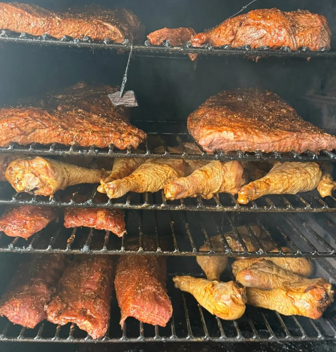 Racks of ribs, chicken and turkey legs inside the smoker