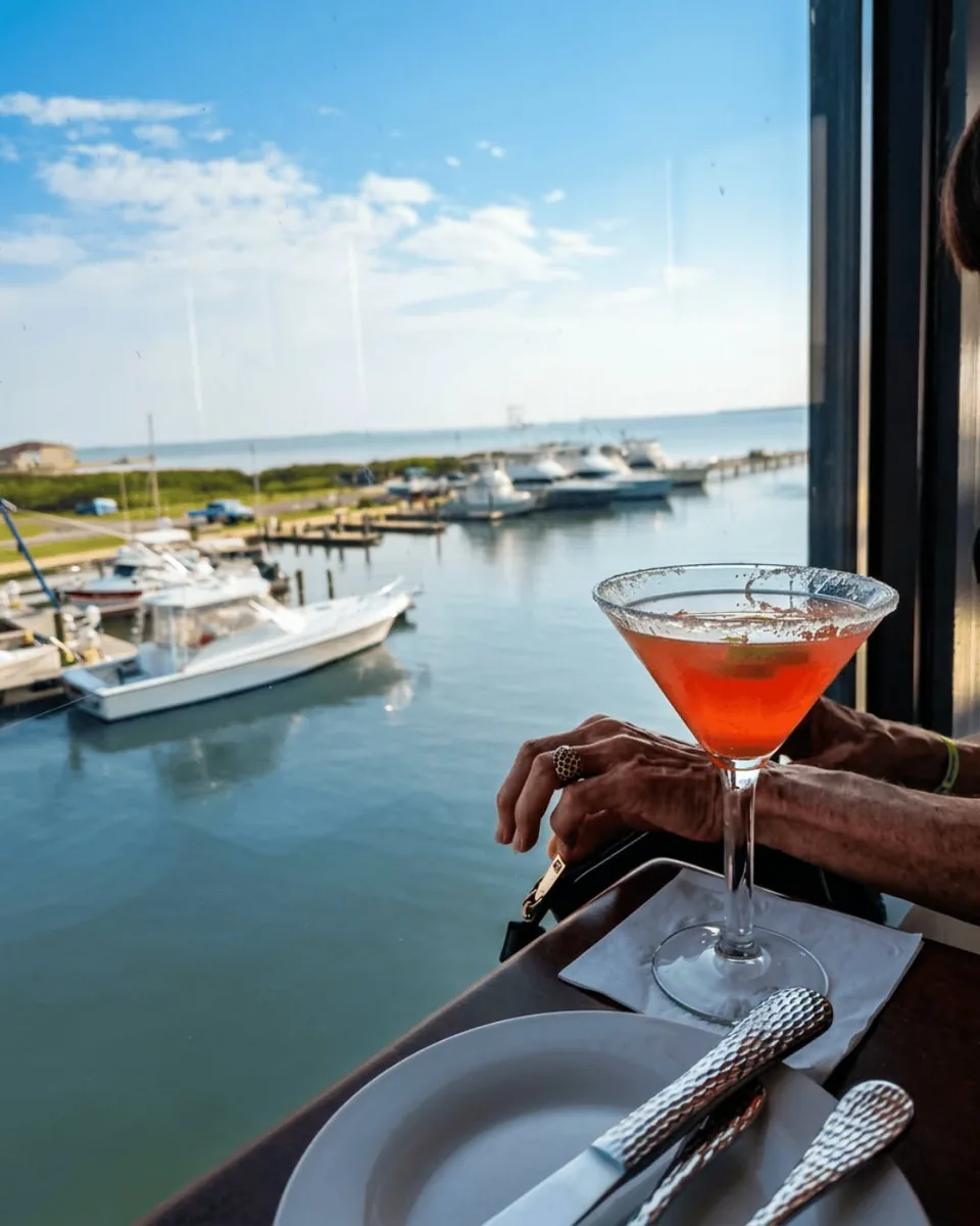 A pink martini at a window table upstairs, looking out over the marina and the bay
