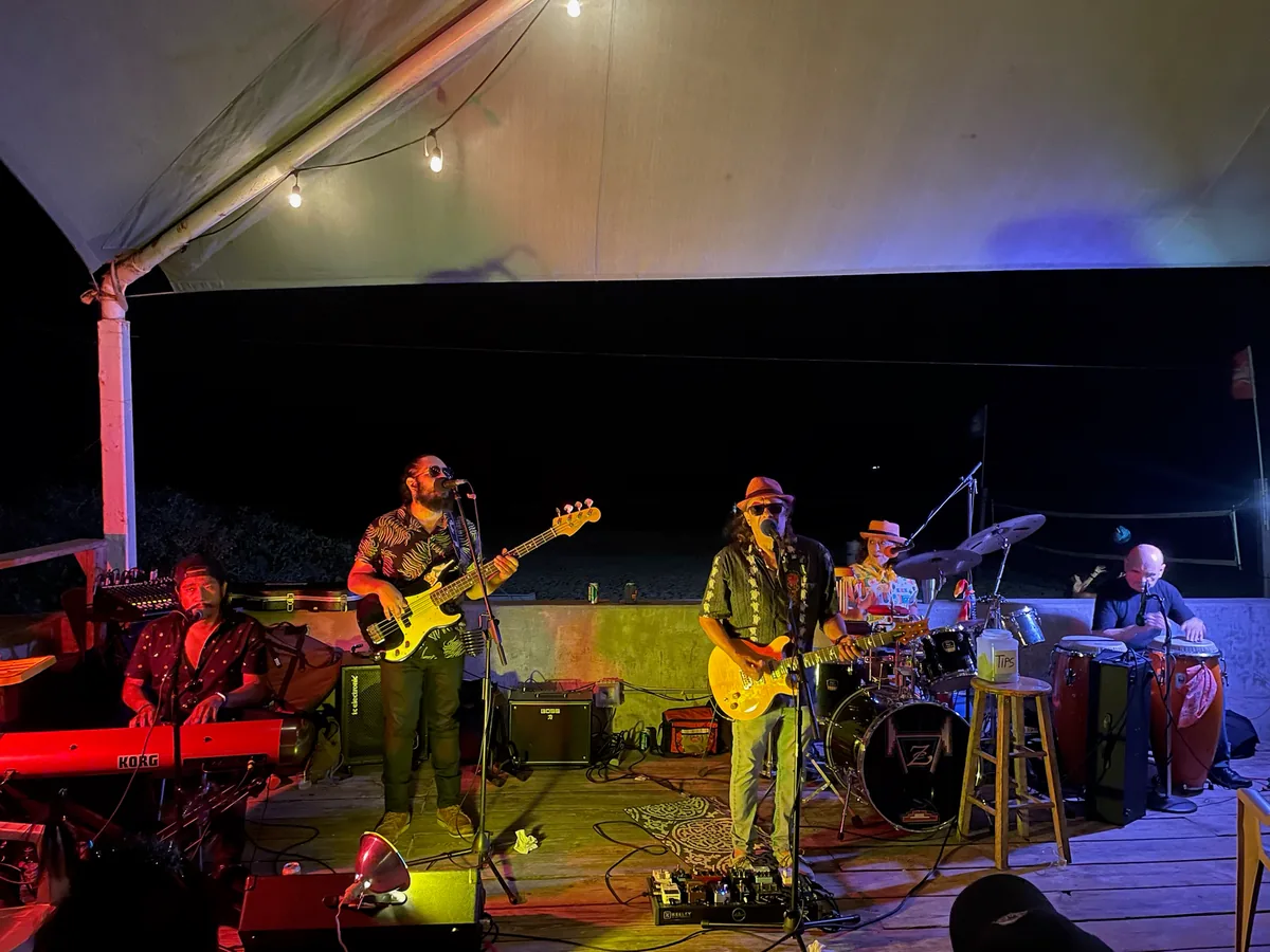 A band playing on the covered stage at night